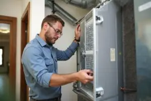Certified technician replacing an HVAC air filter in a Peoria home